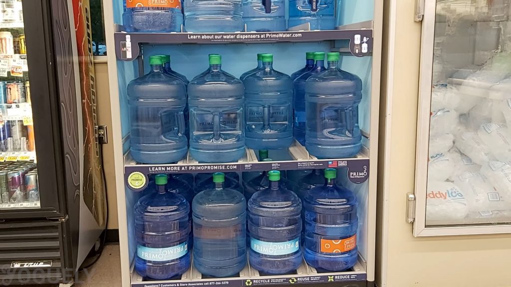 Prefilled water jugs intended to be reusable and refillable at the grocery store's self-serve station. 